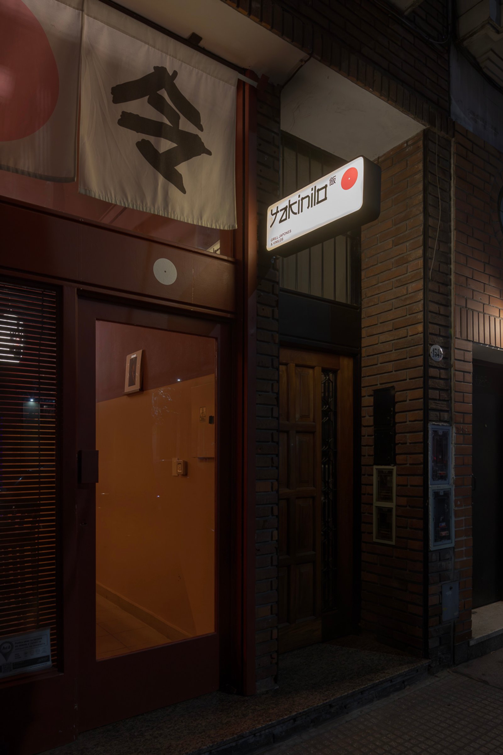 fachada de local comercial con letrero japones y ladrillos — proyecto Yakinilo, por Estudio YME, en Av. Dorrego 1551